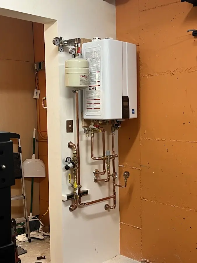 Plumbing technician inspecting water heater connections in Snyder